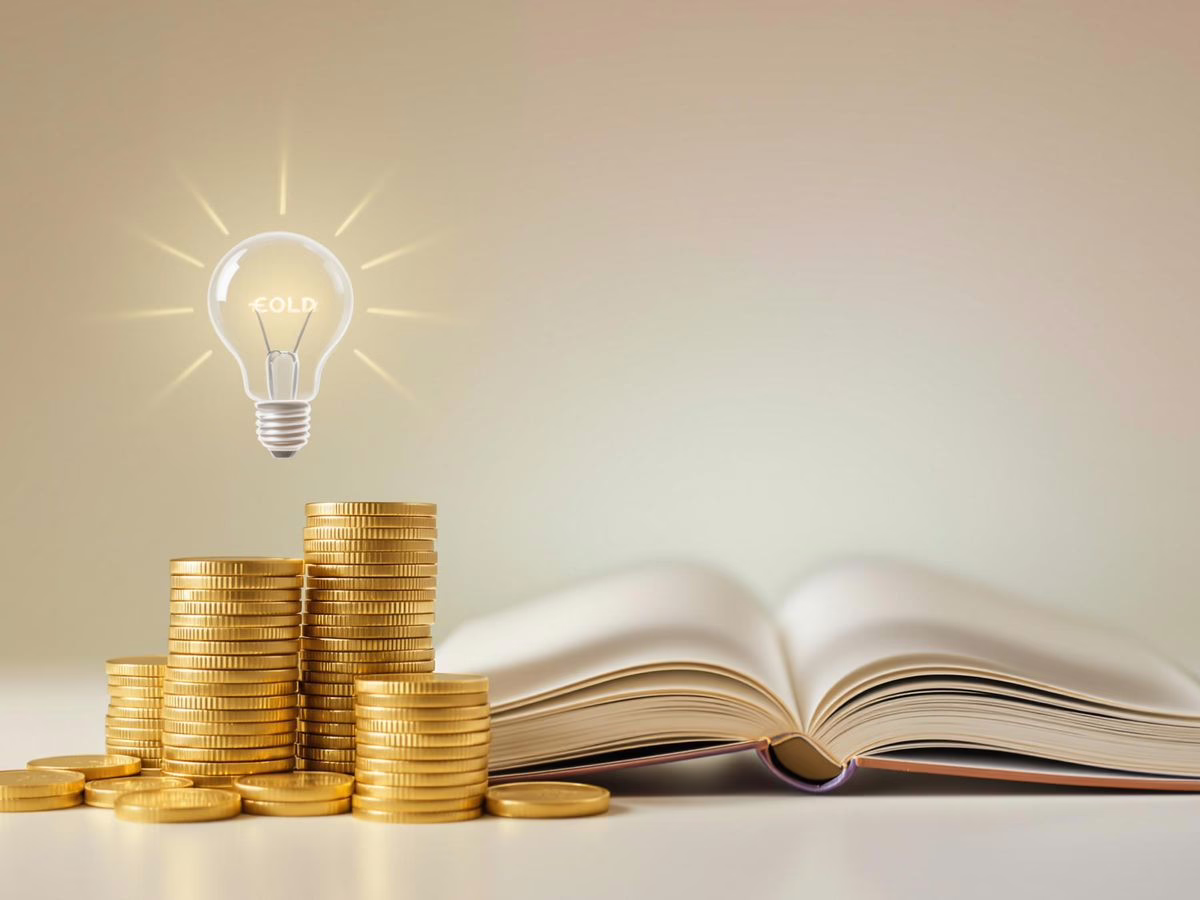 Coins and a book with a lightbulb overhead.